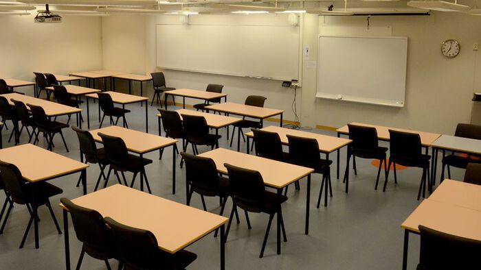 Undervisningsrom med pulter, stoler og tavler
