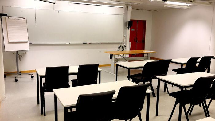 Tavle, stoler og bord i rommet