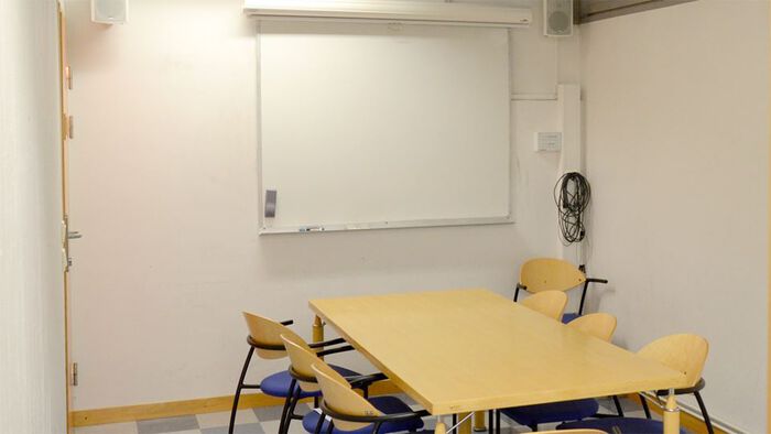 Møterom med bord, stoler og tavle