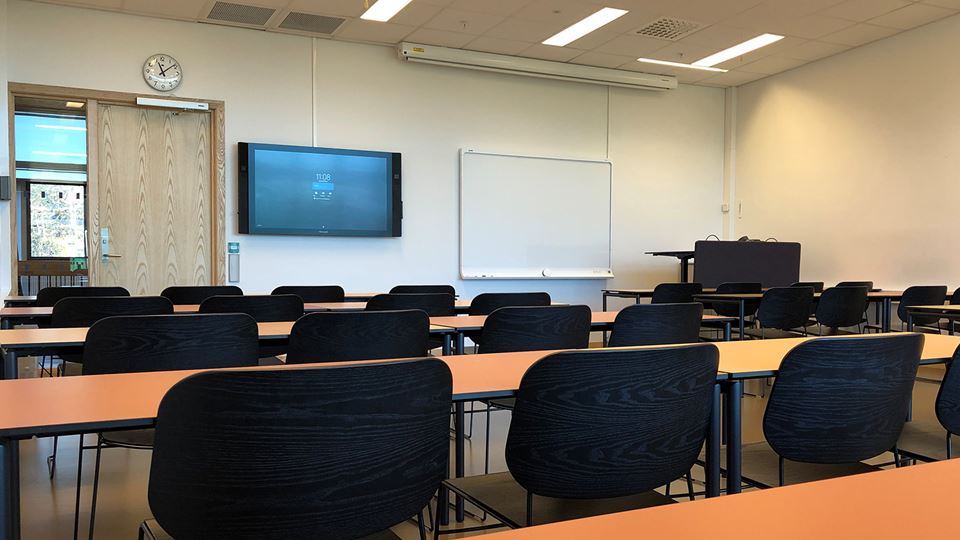 Undervisningsrom med stoler, pulter, skjerm og tavle