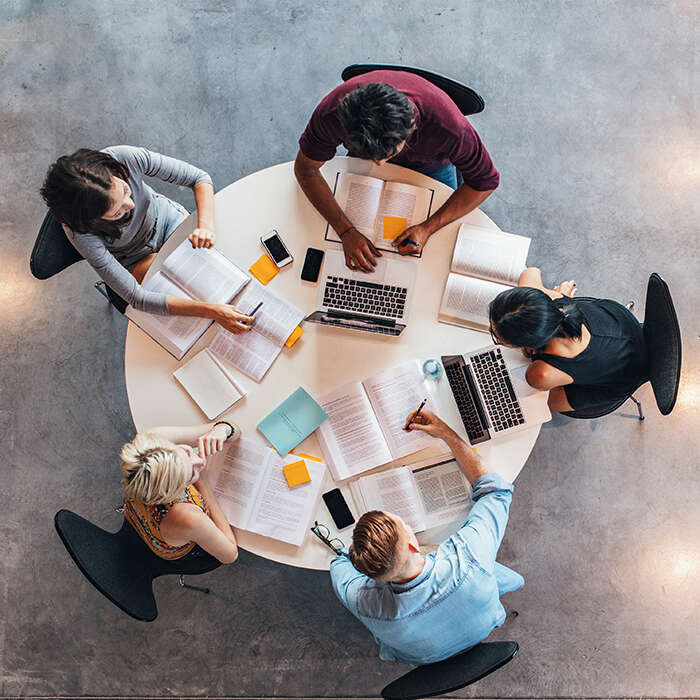 Five students study together around a table
