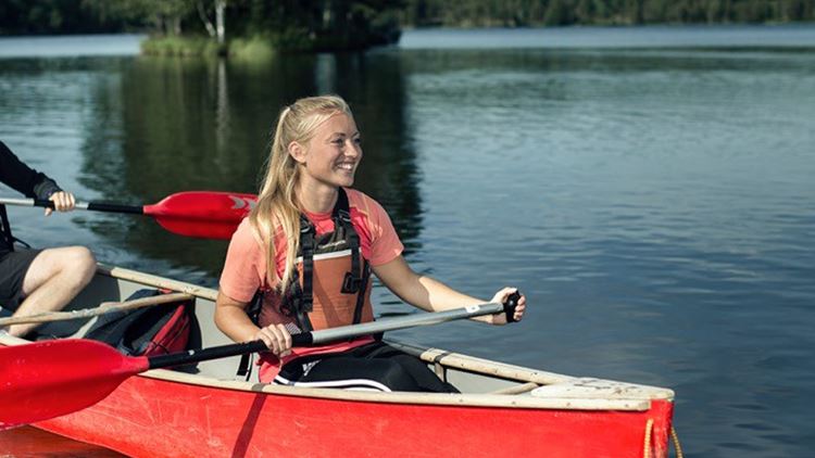 A young smiling woman in a canoe