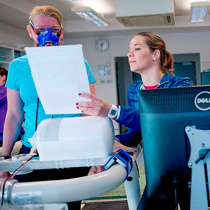 Elderly woman with breathing mask on treadmill being supervised by Gjestvang