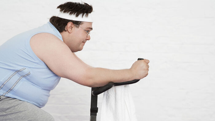 Overweight man on an exercise bike
