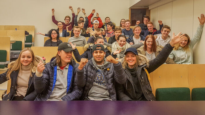 Group of cheering youngsters  in a classroom