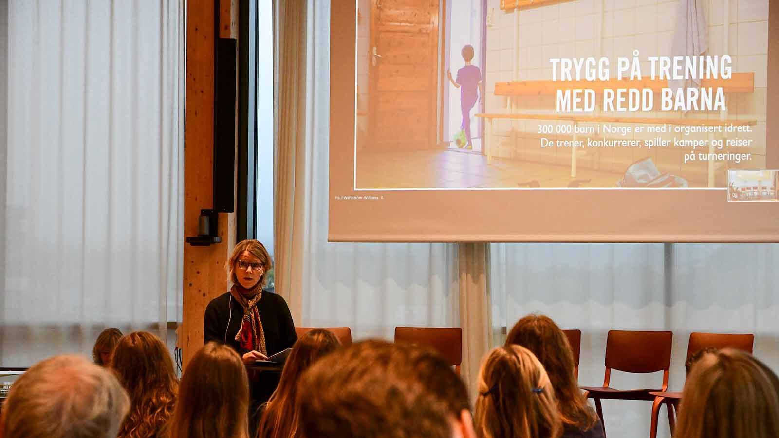 Kvinne held foredrag framfor forsamling