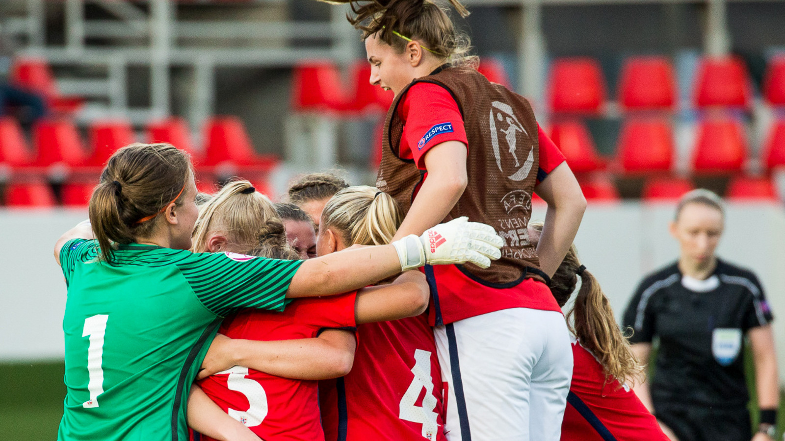 Kvinnelige fotballspillere jubler – hopper opp på hverandre
