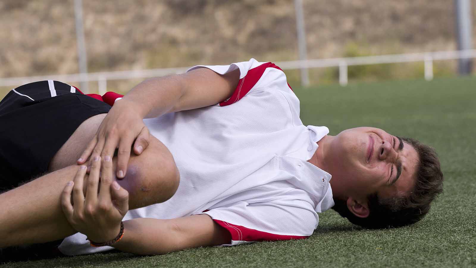 Boy gets hurt in his knee at football pitch