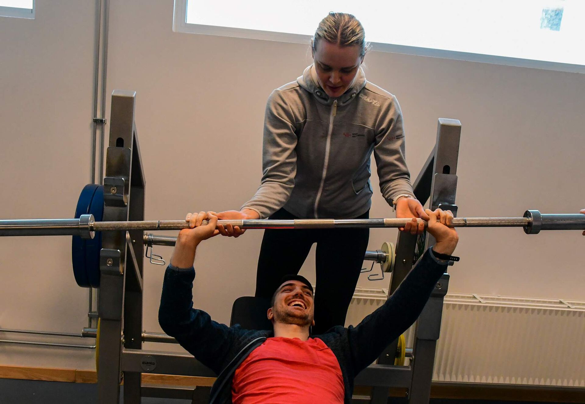 Løftar benkpress med trenar bak