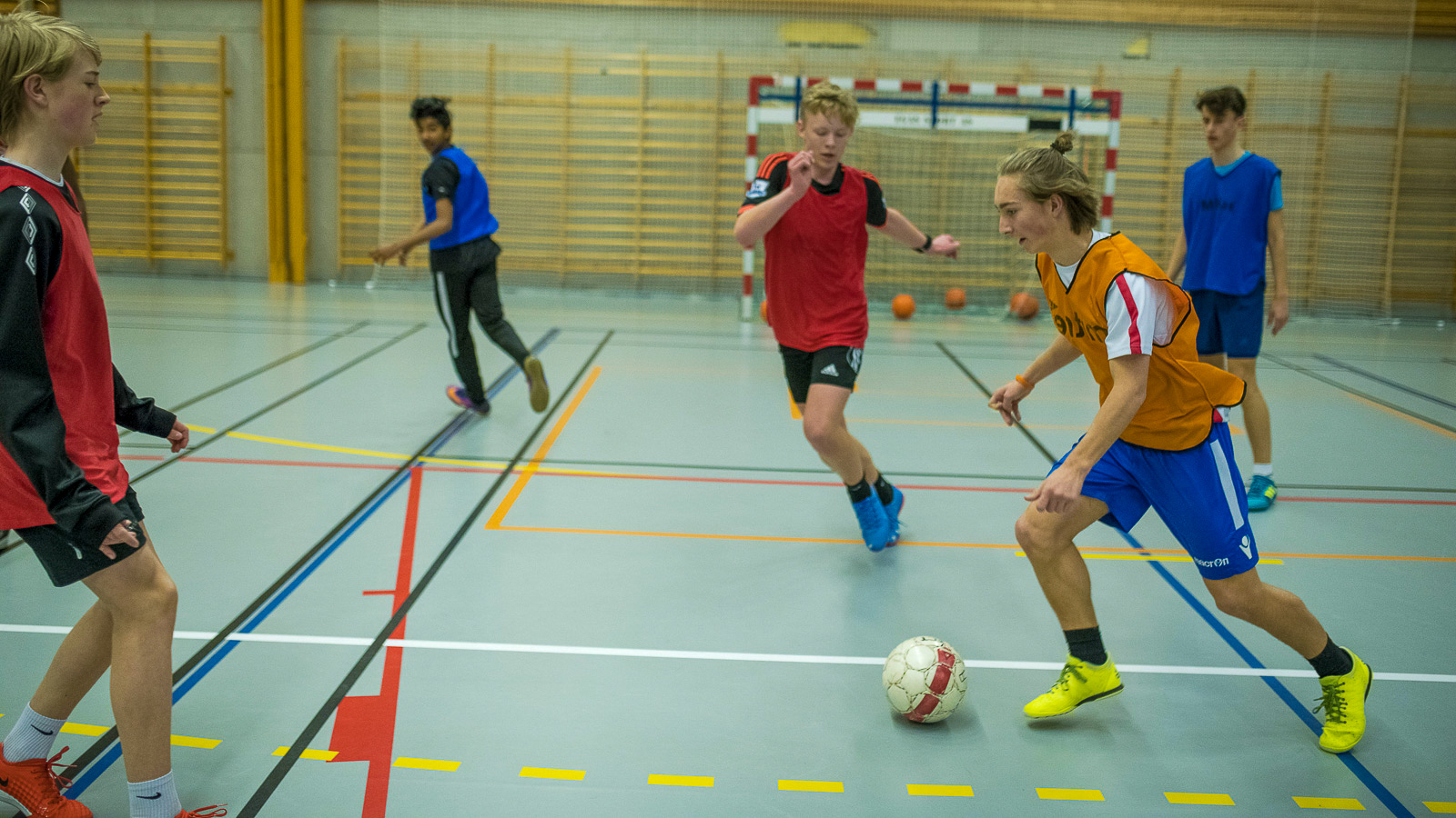 Ungdom spiller fotball i gymsal