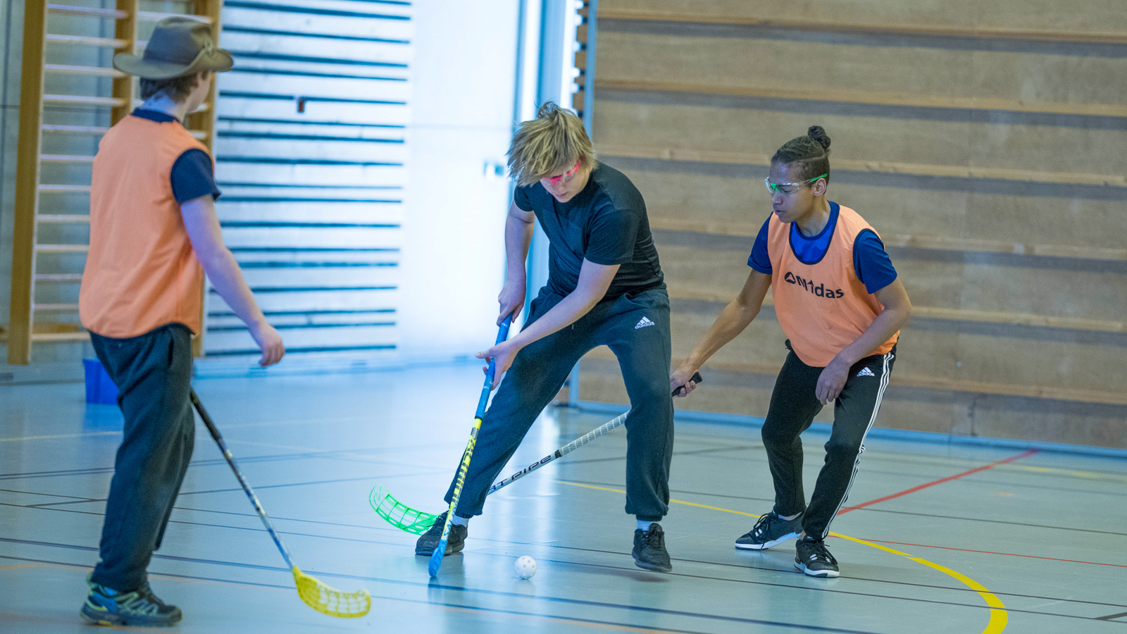 Tre ungdommer spiller innebandy