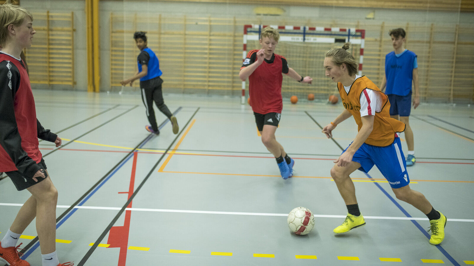 Gutar som spelar fotball i gymsal