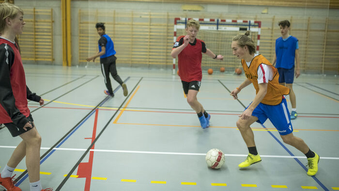 Gutar som spelar fotball i gymsal