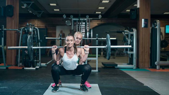Two young girls doing squats