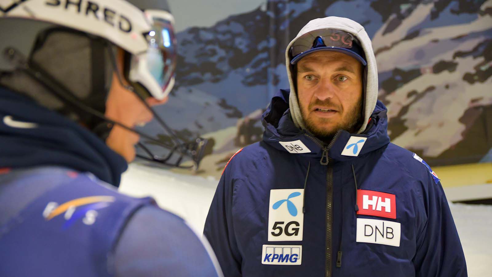 Coach talks to a alpine athlete in a indoor ski hall