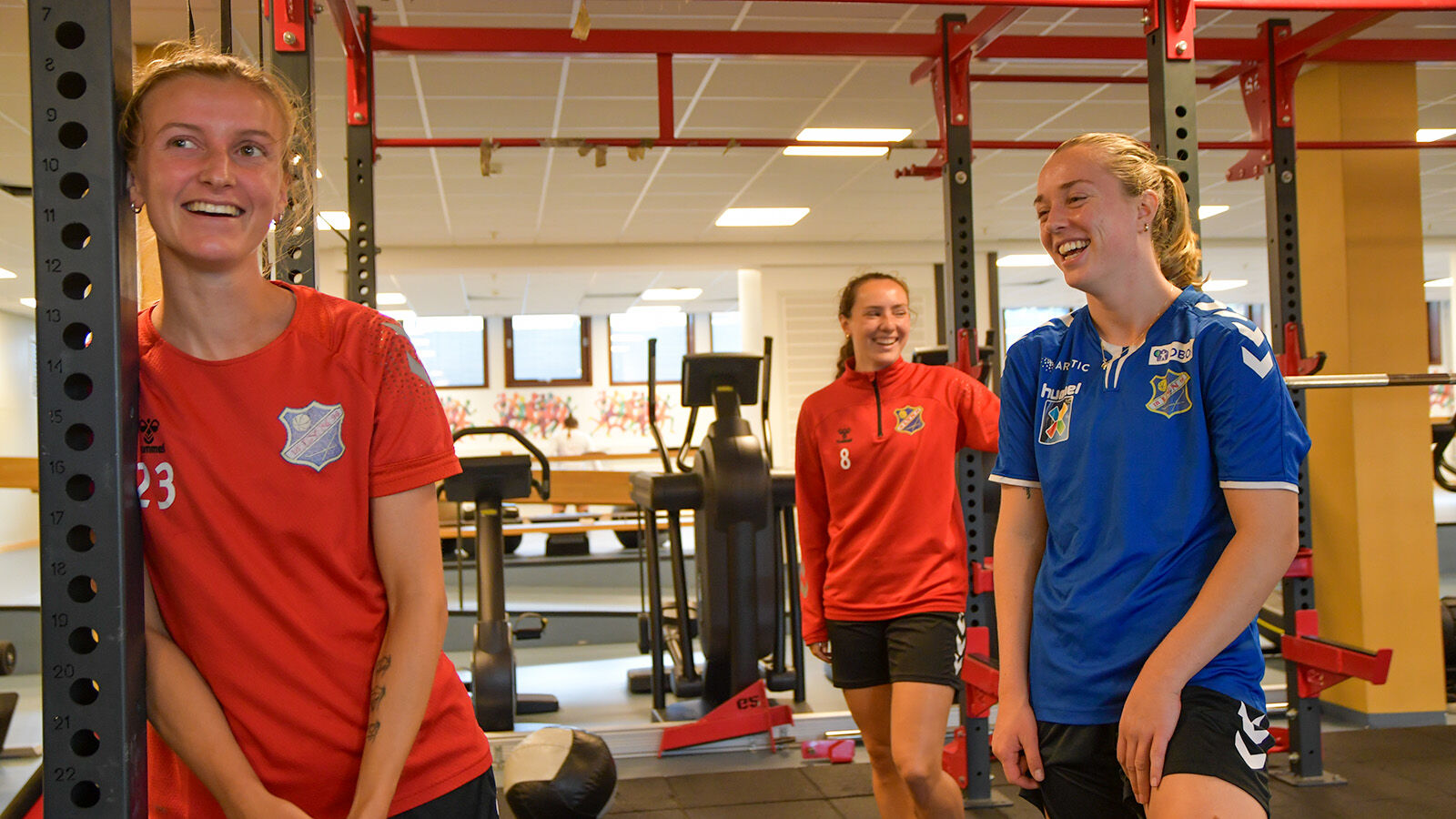 Jenter smiler i styrkerommet
