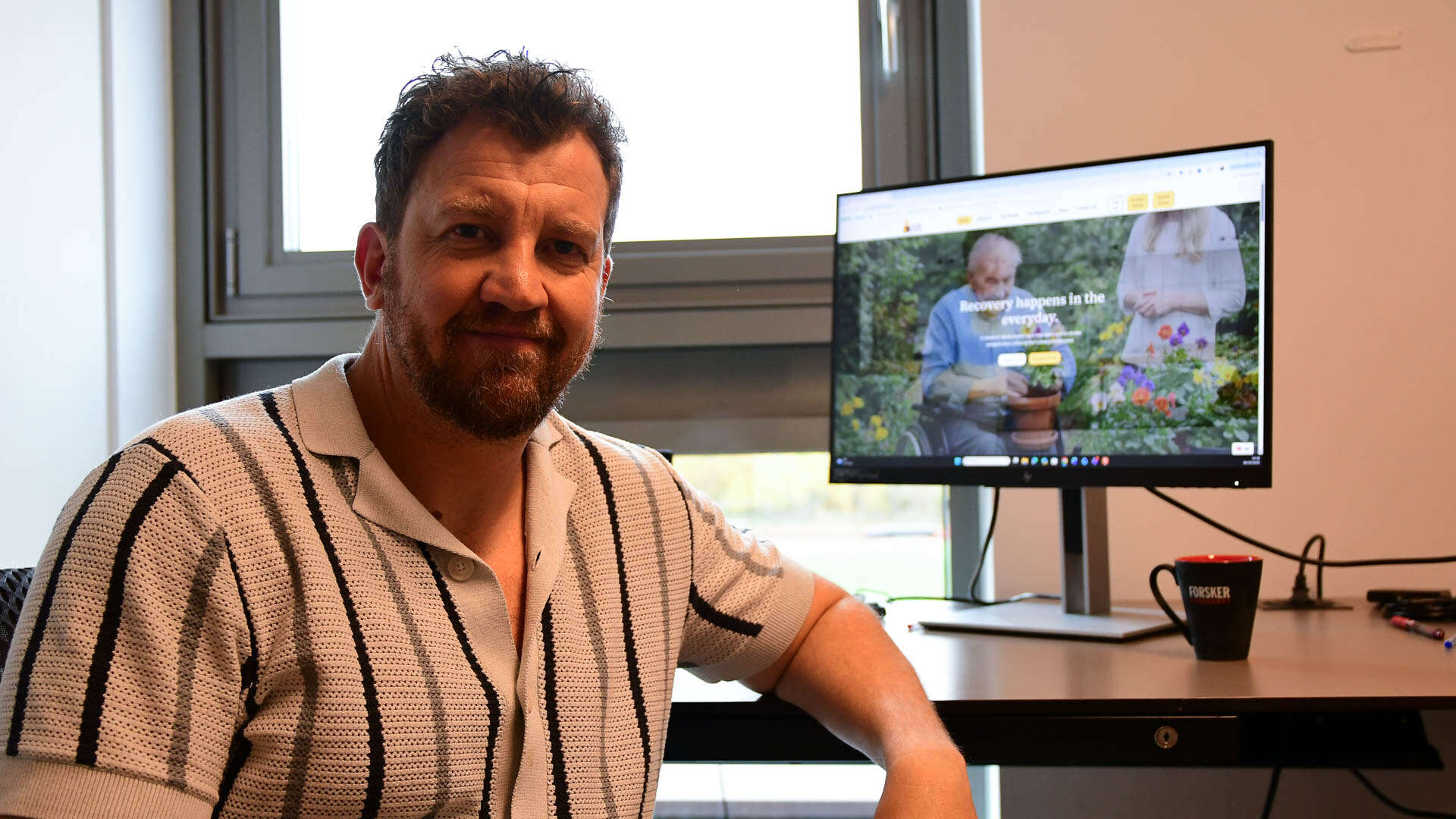 Man posing in front of pc screen. 