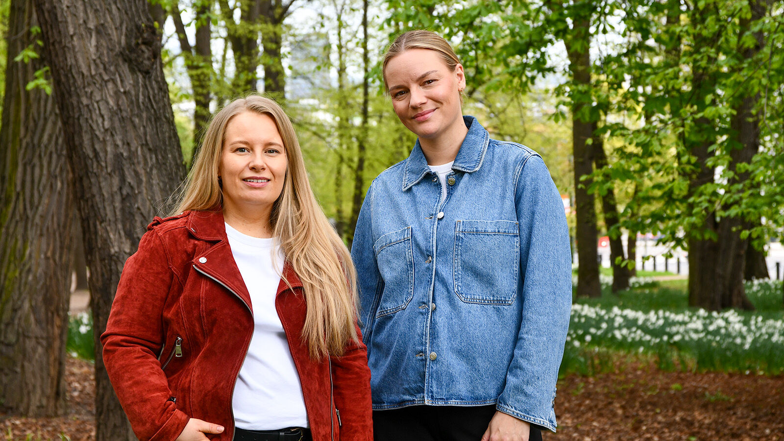 To damer står i park og smiler