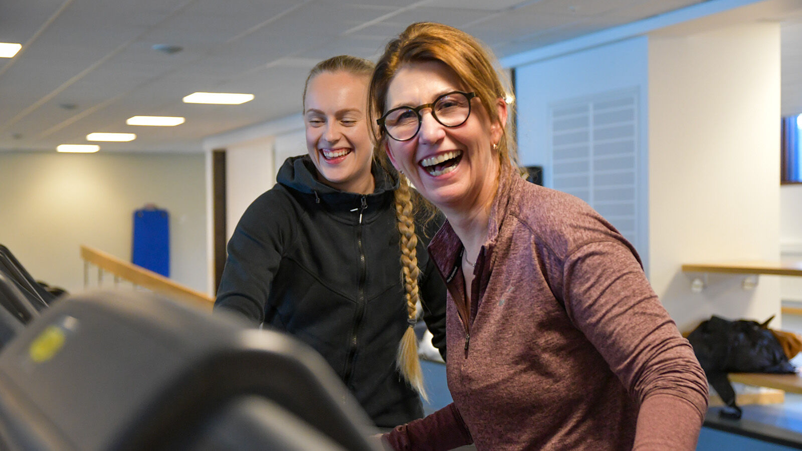 Glisande Monica på tredemølla med PT i bakgrunnen