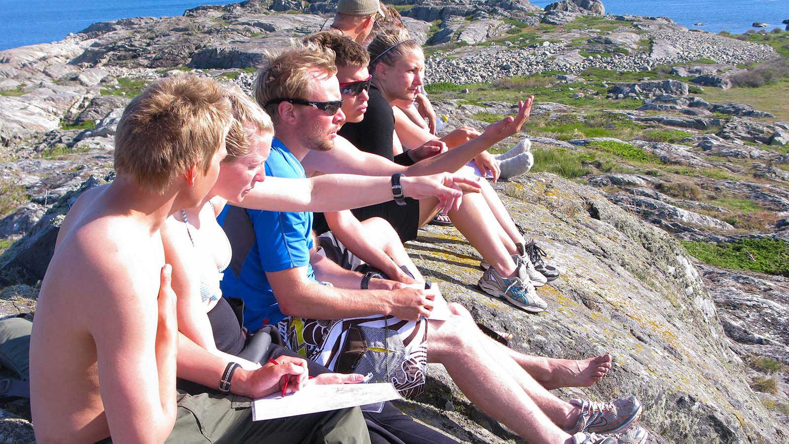 Seks studenter på fjellet snakker sammen