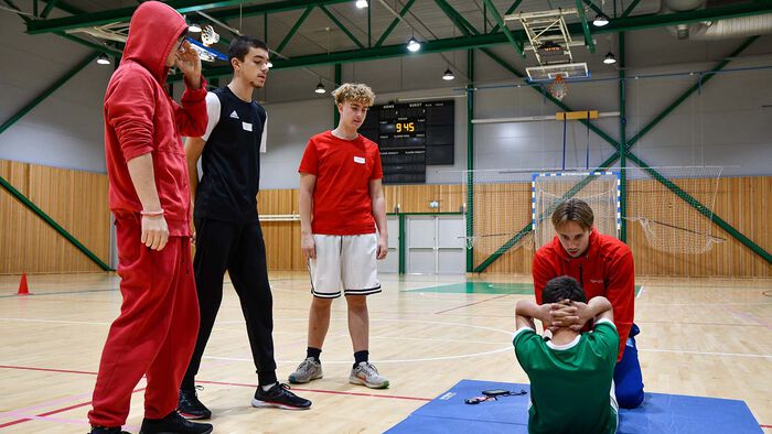 Ungdommer som tar sit-ups i gymsal