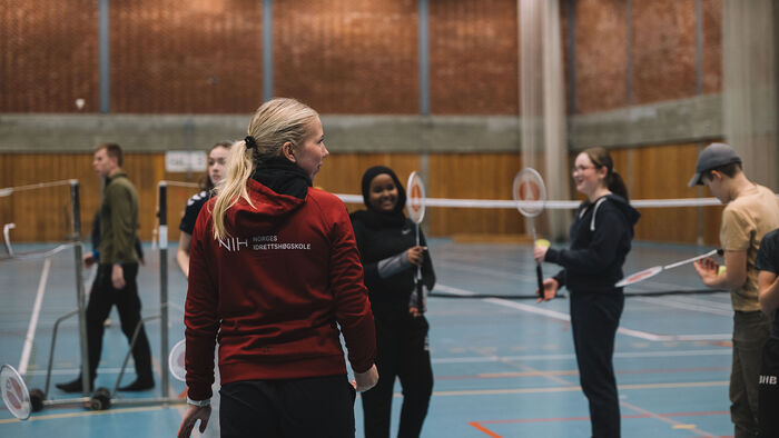 Student instruerer elevar i badminton i hall