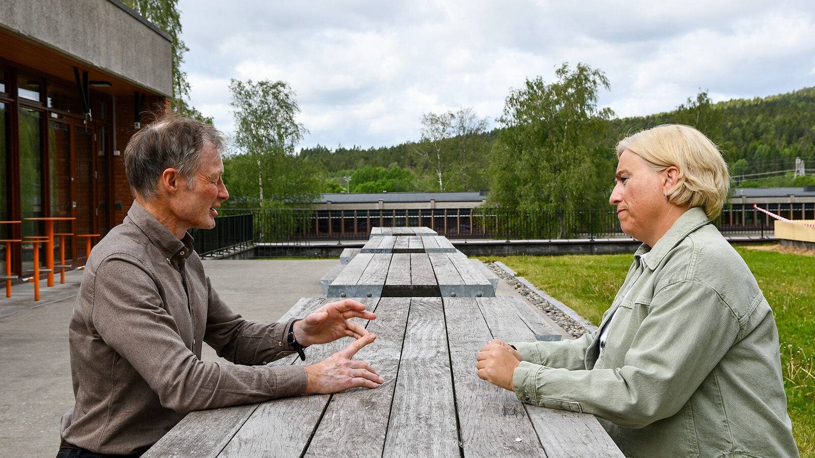 Elin og Lars Tore diskuterer utanfor kantina