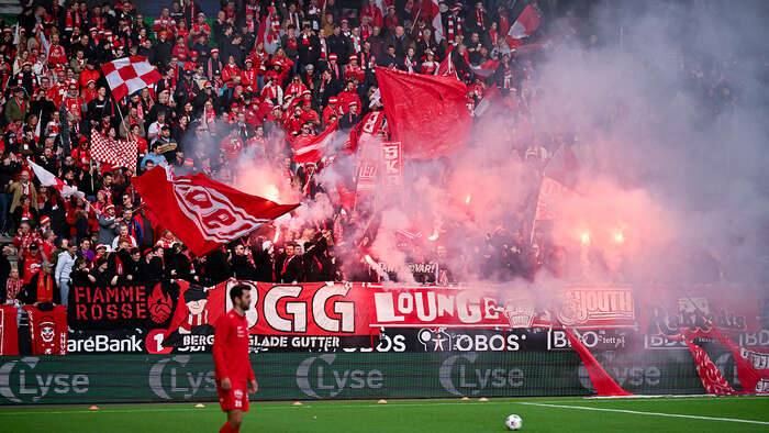 Supportarar som jublar og har bluss på tribunen. 