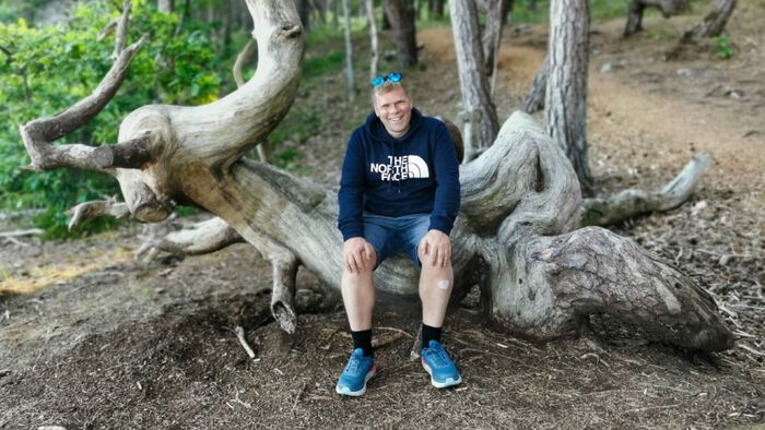 Christian på tur sit på ein stubbe