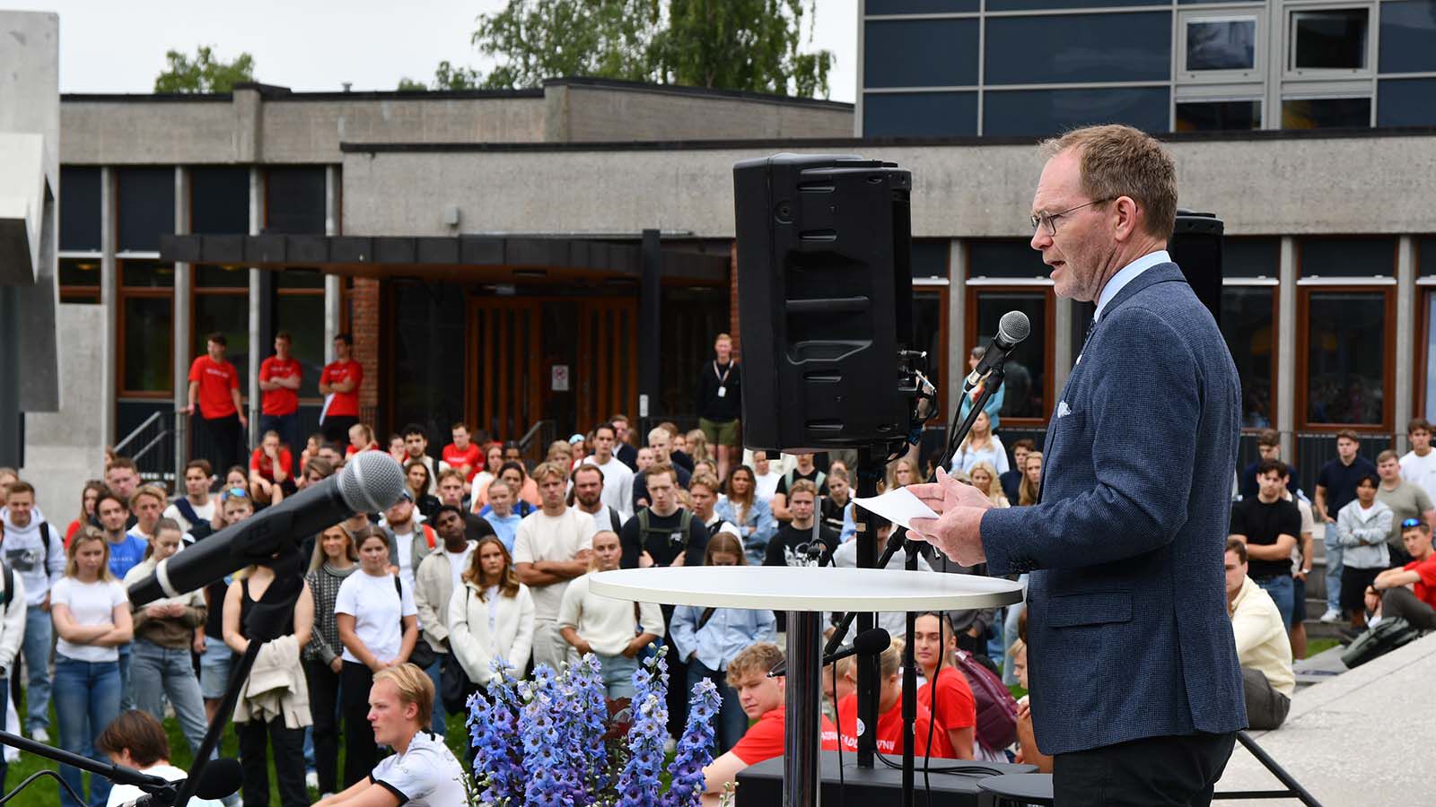 Bildet kan inneholde: mikrofon, vindu, slips, mengde, hendelse.