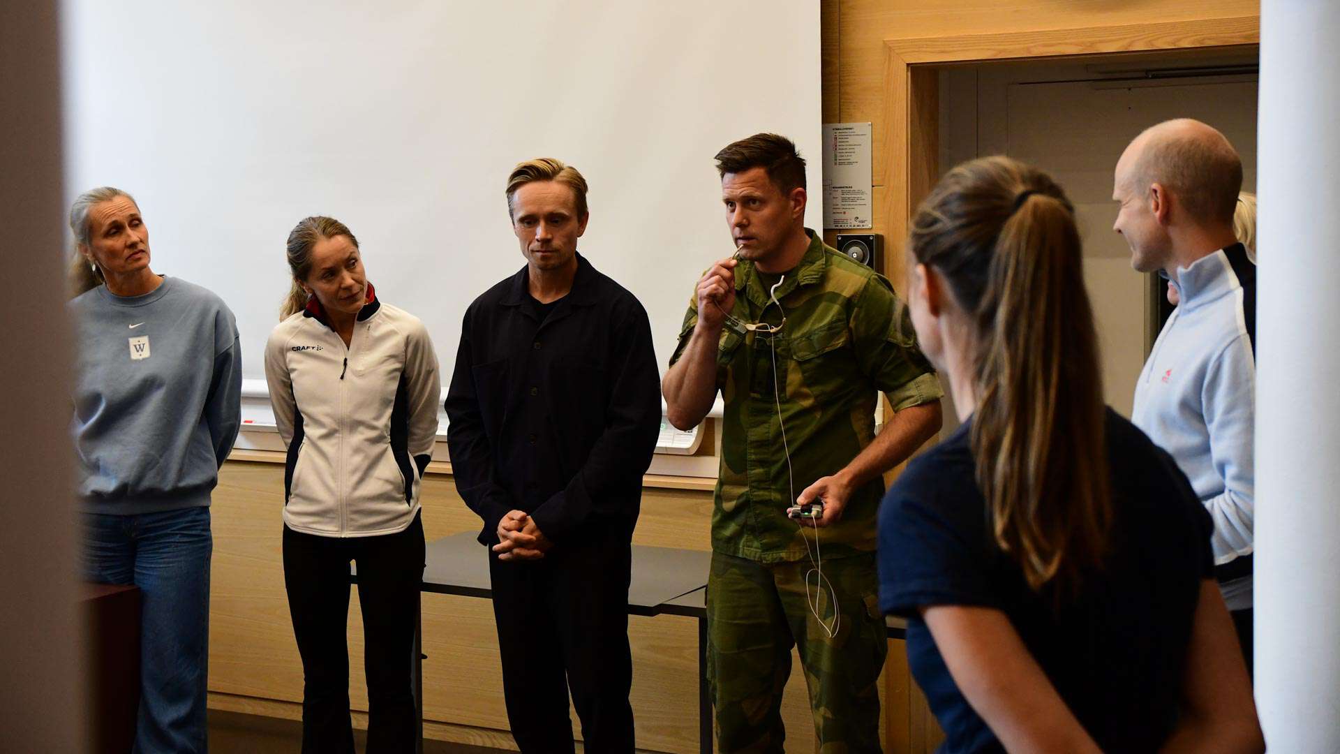 Paneldeltakere lytter til mann som prater i mikrofon.