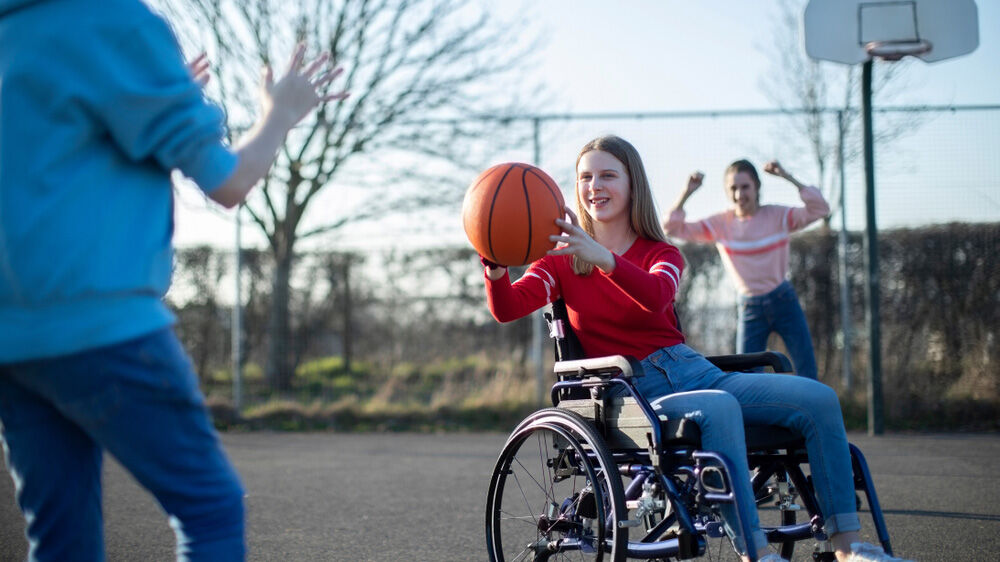 Barn med funksjonsnedsettelse deltar i basket sammen med medspillere”