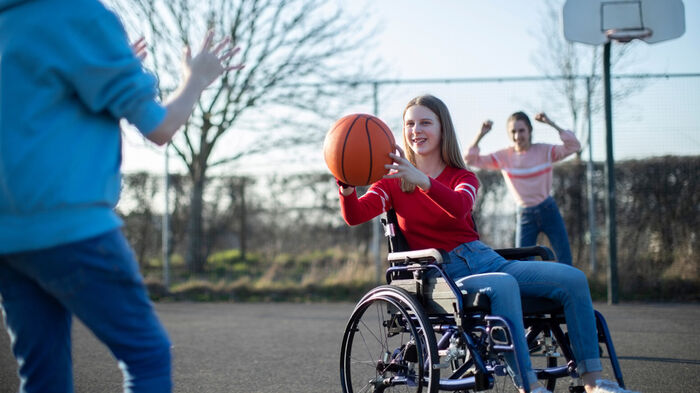 Barn med funksjonsnedsettelse deltar i basket sammen med medspillere”
