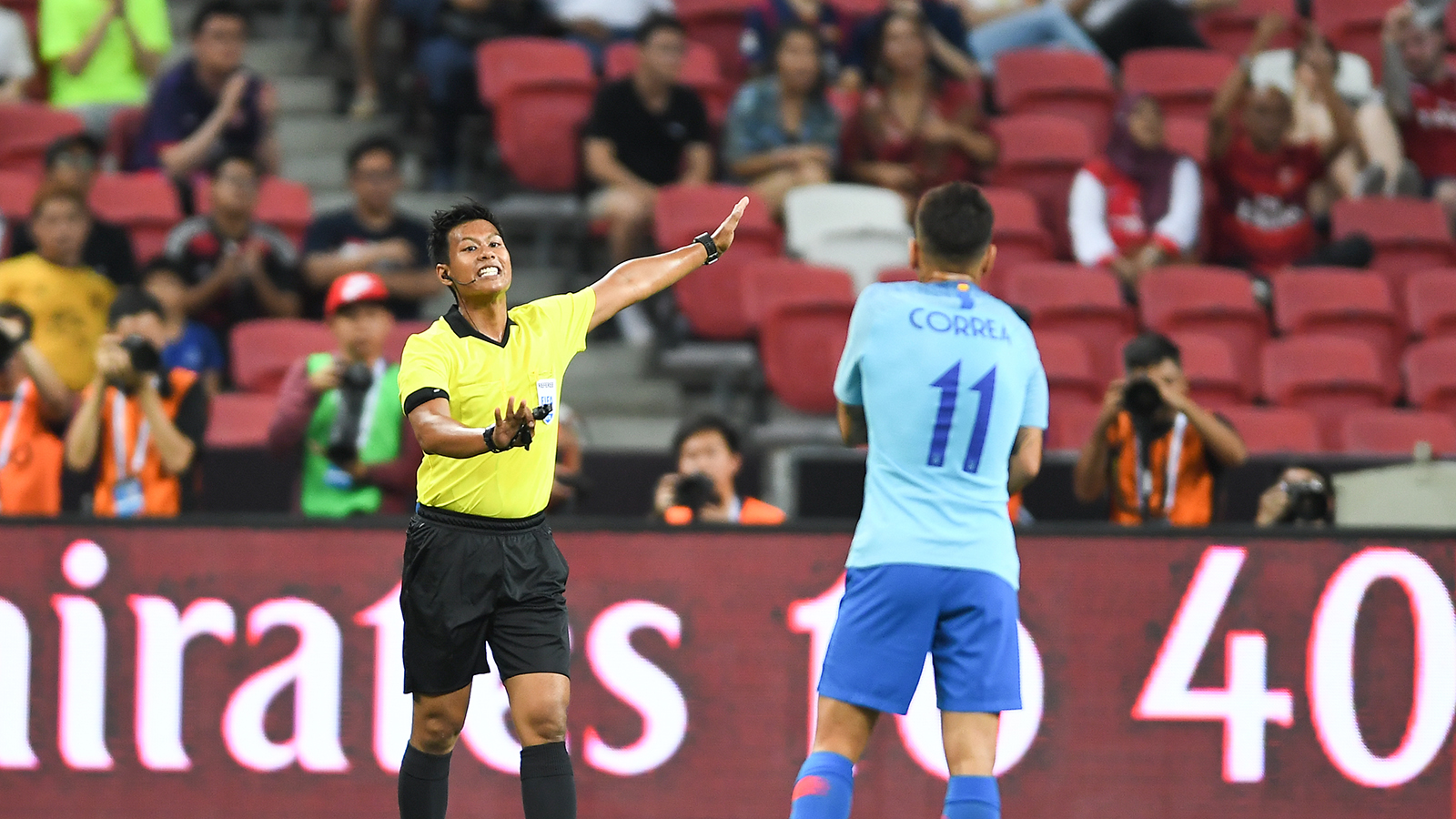 Dommeren signaliserer straffen til en spiller fra Atletico Madrid