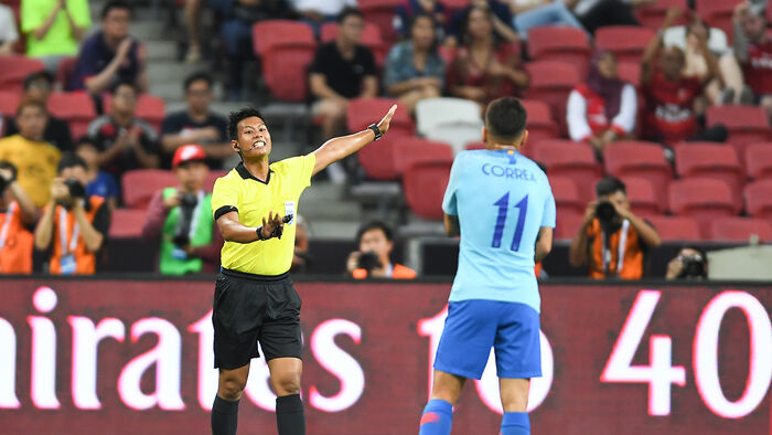 Dommeren signaliserer straffen til en spiller fra Atletico Madrid