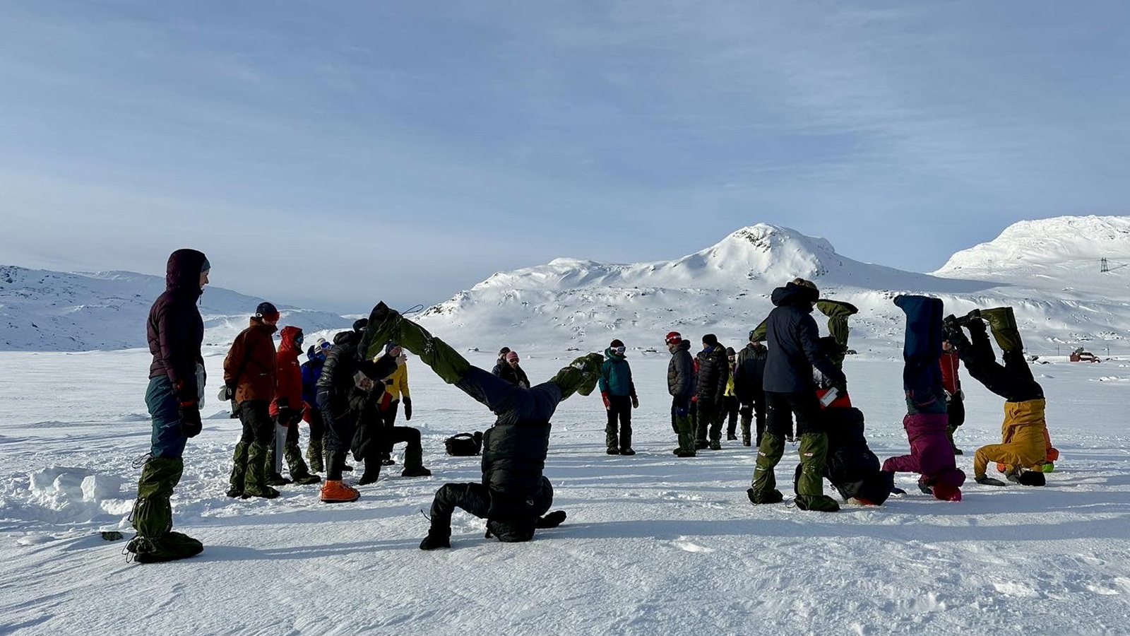Noen studenter tester sine ferdigheter ti å stå opp ned i snøen.