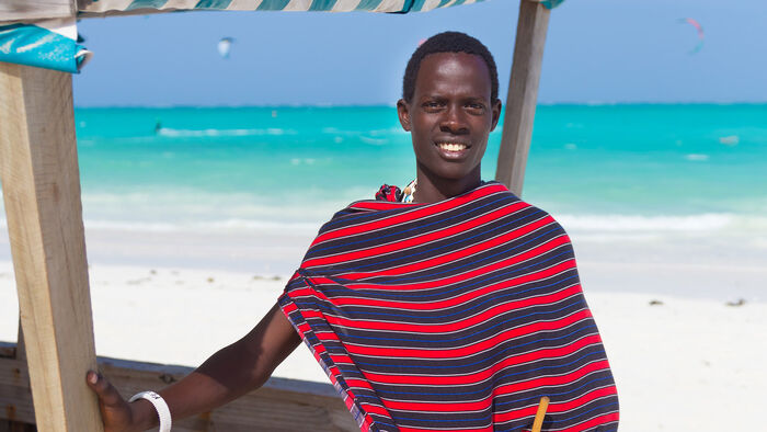 Maasai-mann lener seg mot en båt