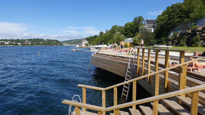 Folk bader ved en nybygd badeplass