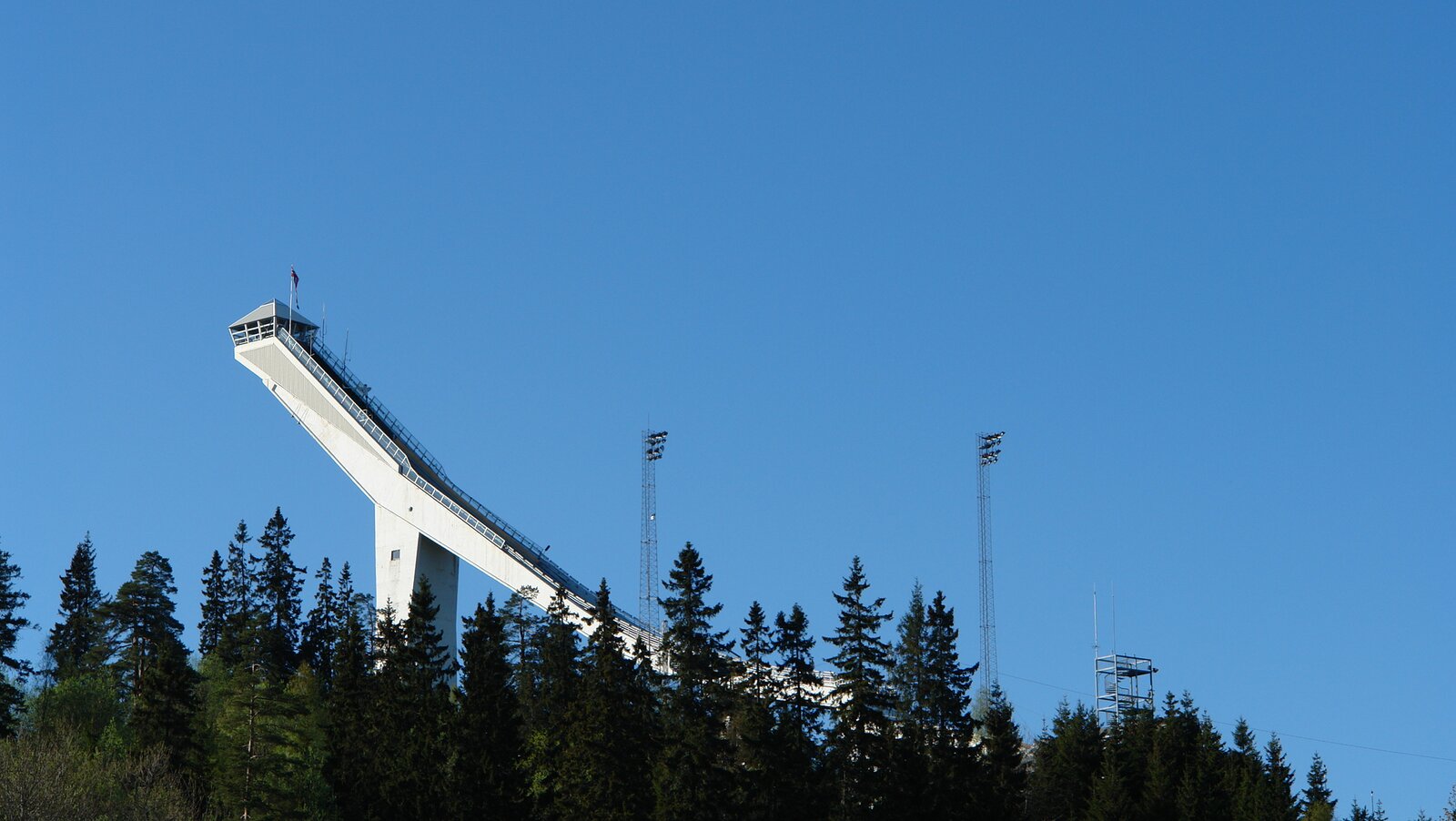 Holmenkollen skihopp fra avstand, bildet med blå himmel
