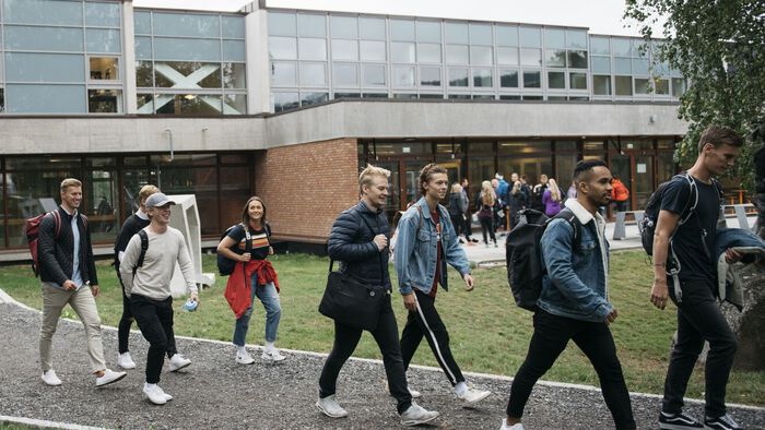 Studenter på vei ut fra NIH, langs grusveien inngang nord