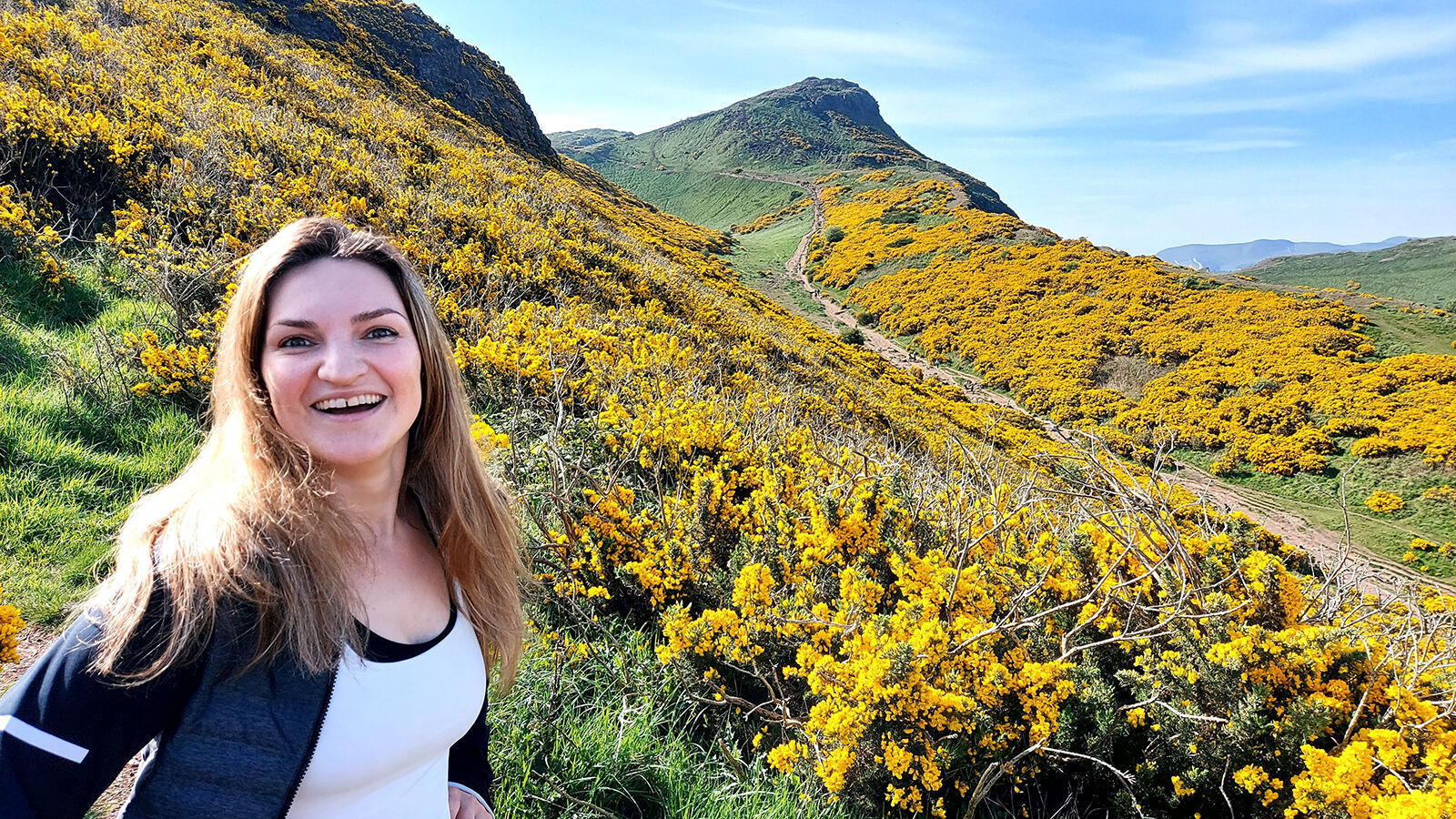 Margrethe smiler på stigen på vei opp til Arthur's Seat. 