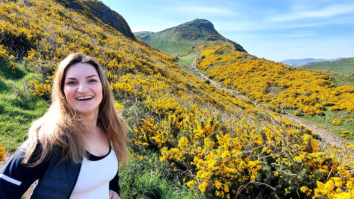 Margrethe smiler på stigen på vei opp til Arthur's Seat. 