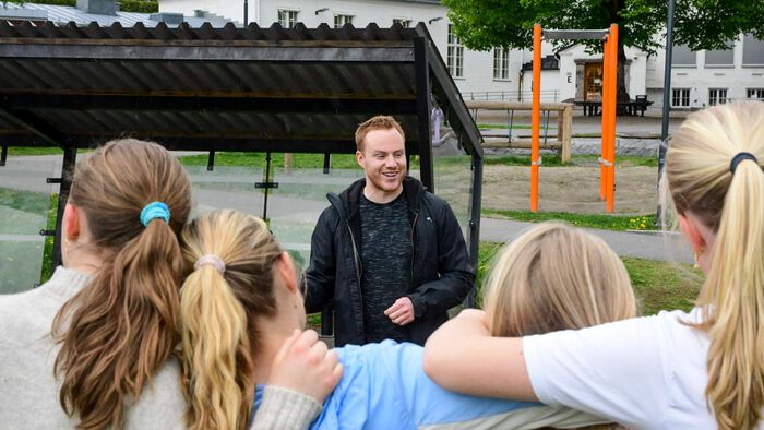 Lærar snakkar til elevane. Elevane er blurry, lærar i fokus.