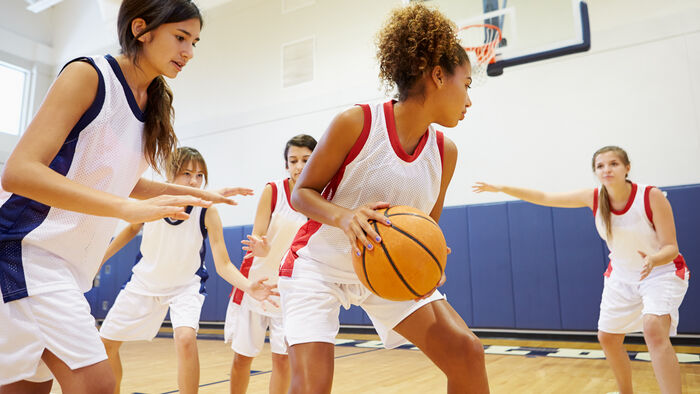 Girls of different ethnicities playing basketball