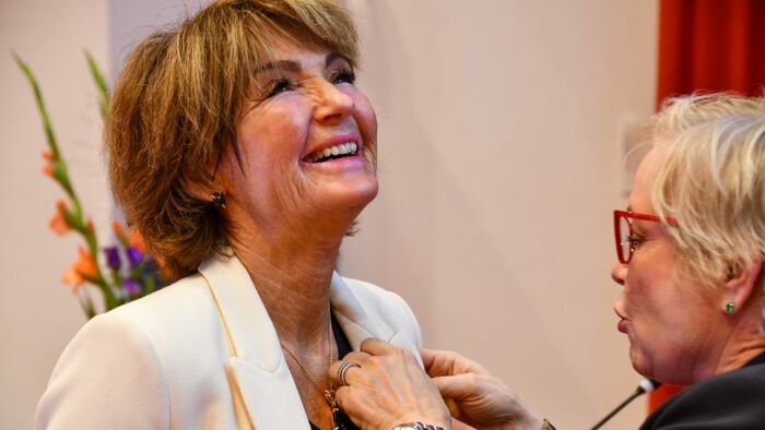 Jorunn Sundgot-Borgen smiler og tar imot medlajen. 