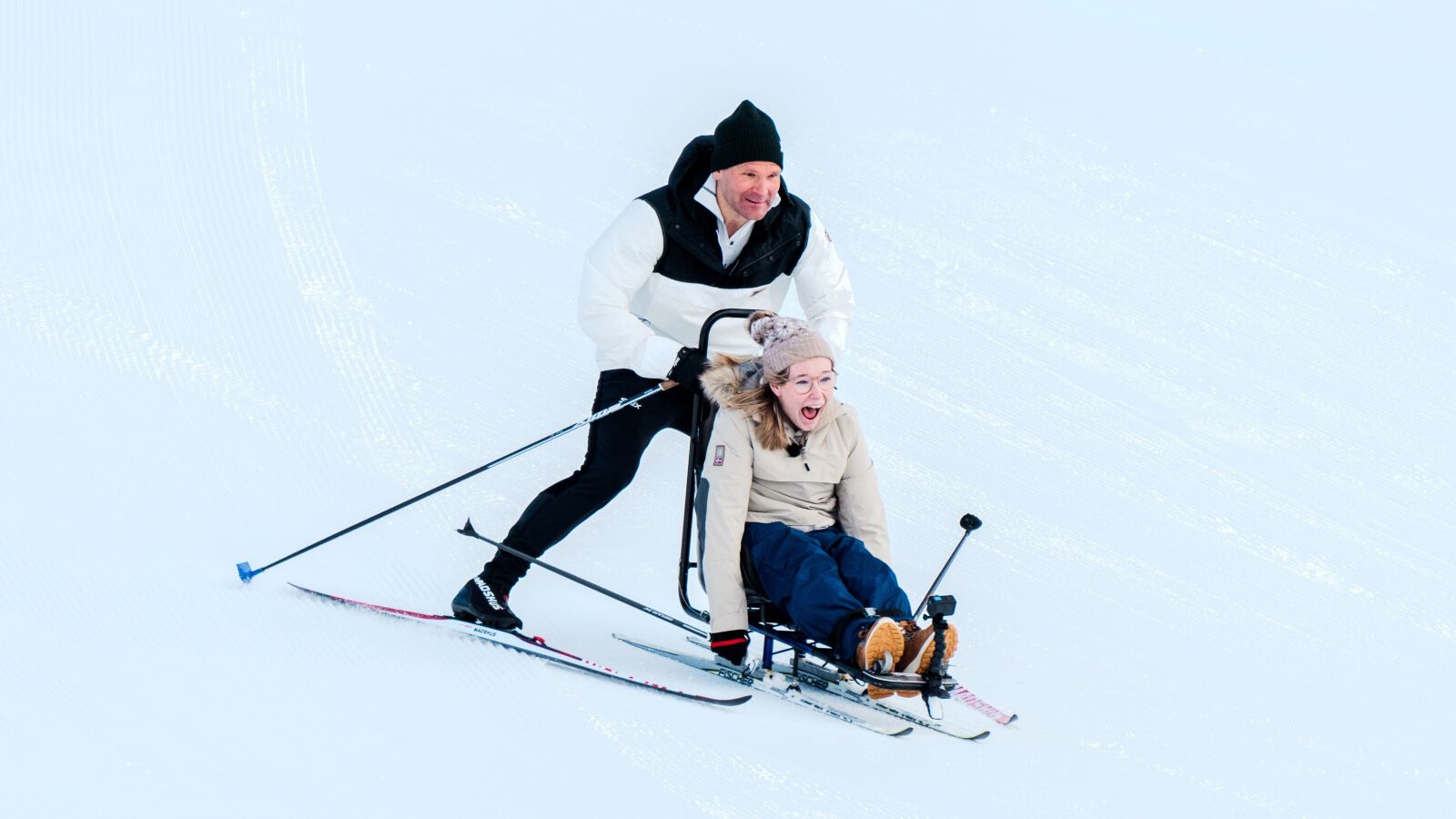 Øystein Pettersen står på ski sammen med  Pia Hasund Vareberg nedoverbakke