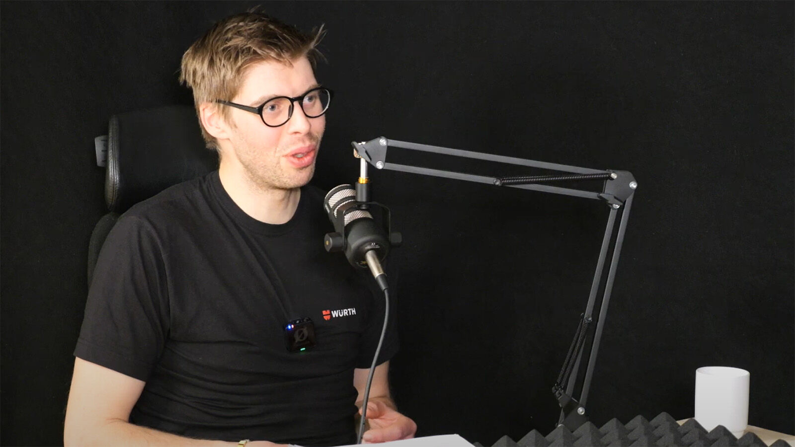 Kristian foran mikrofon i podkast-studio