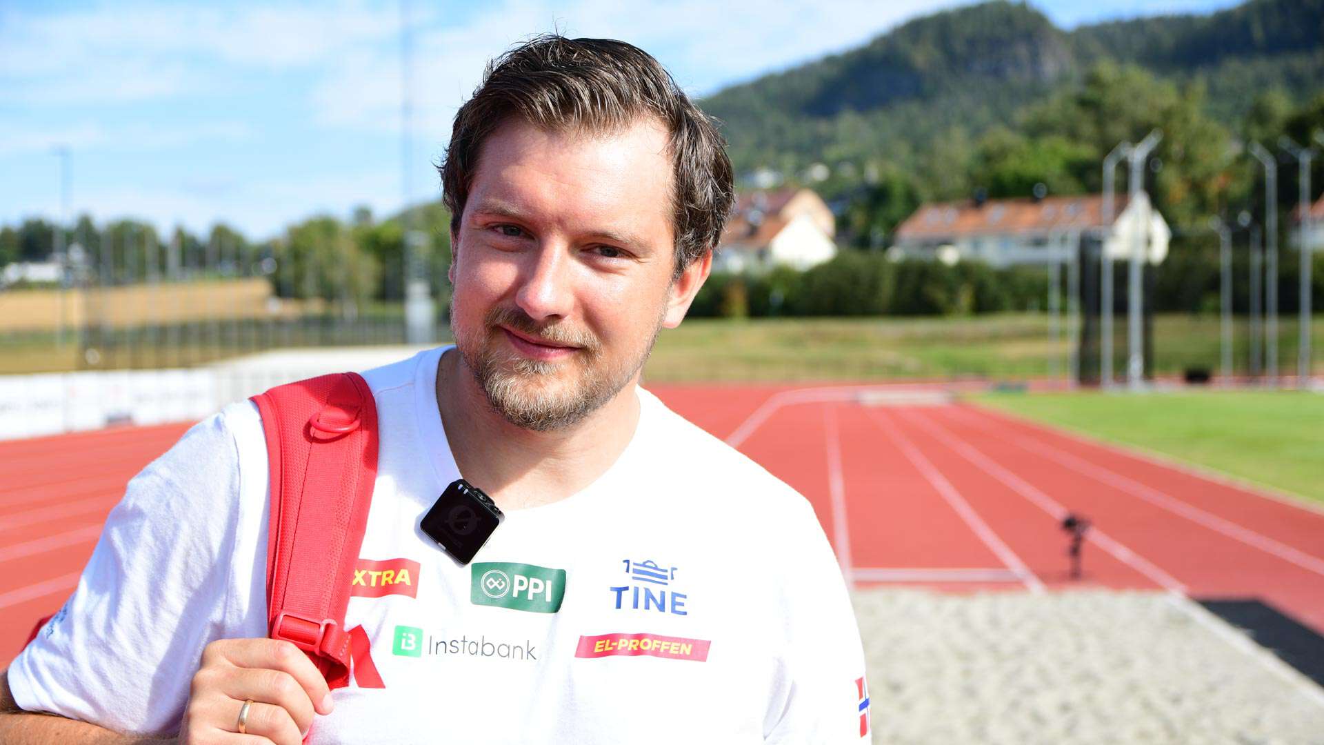 Mann står foran en hoppgrop i et utendørs friidretsanlegg